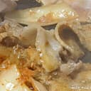 불판에 구워지는 중인 돼지고기와 김치가 찍힌 사진